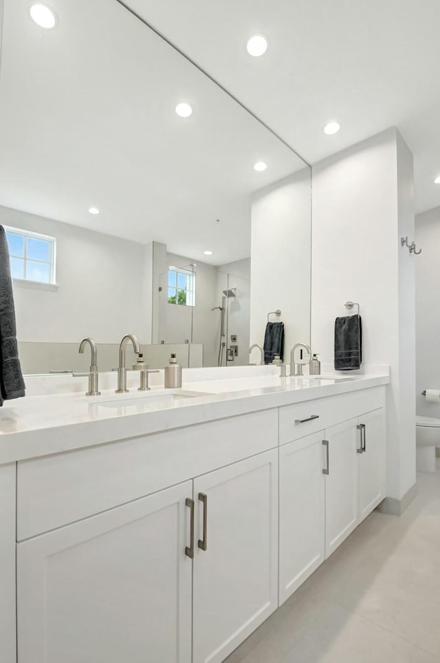 full bathroom featuring recessed lighting, a sink, toilet, and double vanity