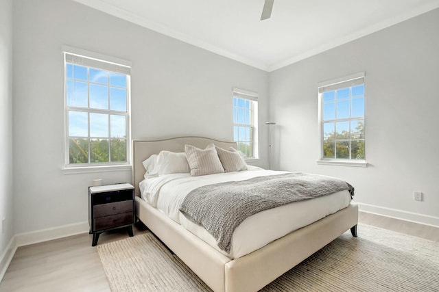 bedroom featuring light wood-type flooring, multiple windows, and baseboards