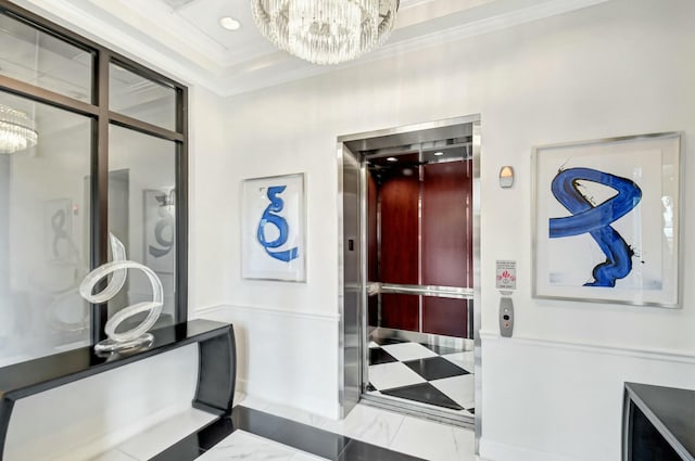 interior space with elevator, marble finish floor, an inviting chandelier, and ornamental molding