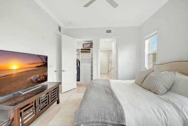 bedroom with crown molding, a closet, visible vents, a spacious closet, and a ceiling fan