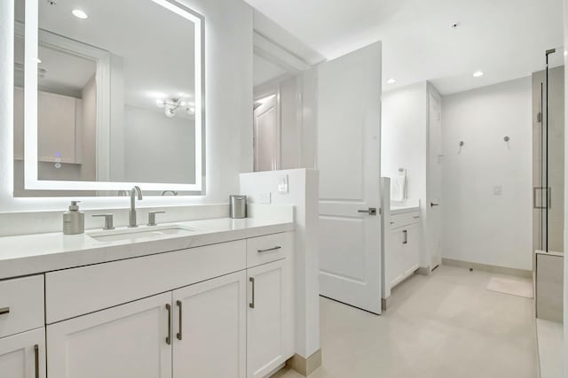 bathroom with vanity, baseboards, and recessed lighting