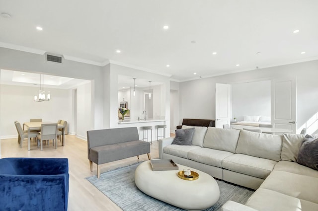 living area with recessed lighting, visible vents, baseboards, light wood-type flooring, and crown molding