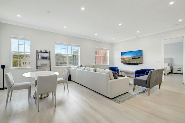 living room with light wood-style floors, ornamental molding, and recessed lighting