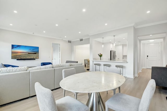 dining room featuring recessed lighting, visible vents, light wood-style flooring, ornamental molding, and baseboards