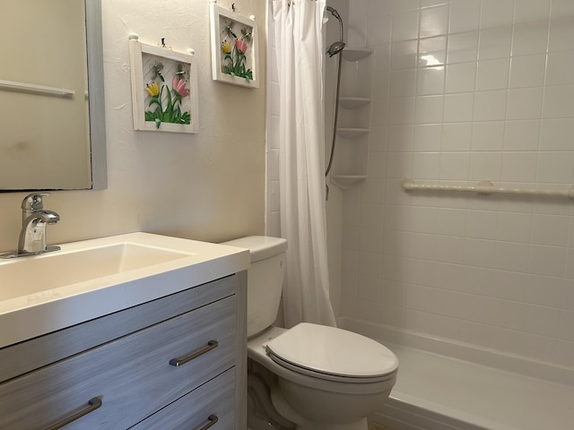 bathroom featuring vanity, a shower stall, and toilet