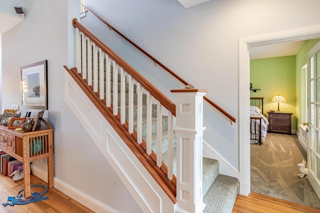 staircase with baseboards and wood finished floors