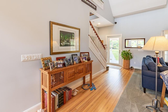 sitting room with stairs, wood finished floors, and baseboards