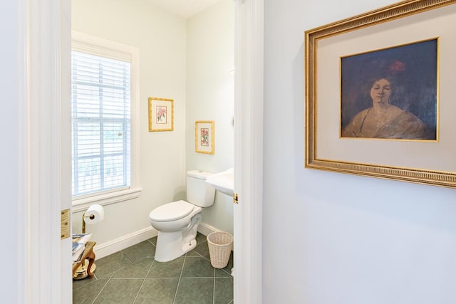 bathroom featuring tile patterned flooring, toilet, and baseboards