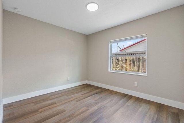 spare room with wood finished floors and baseboards