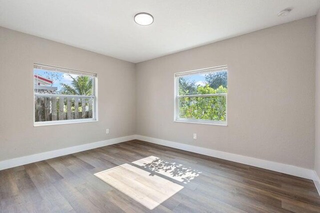 unfurnished room featuring baseboards and wood finished floors