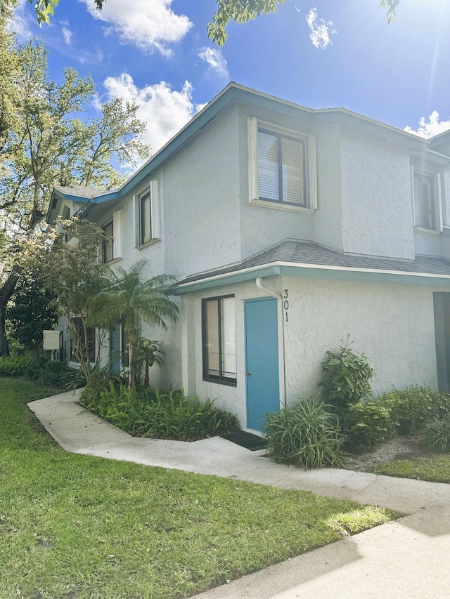 view of front facade with a front lawn and stucco siding