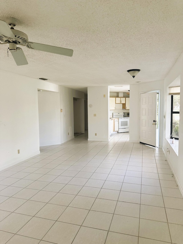 unfurnished living room with ceiling fan, a textured ceiling, and light tile patterned floors