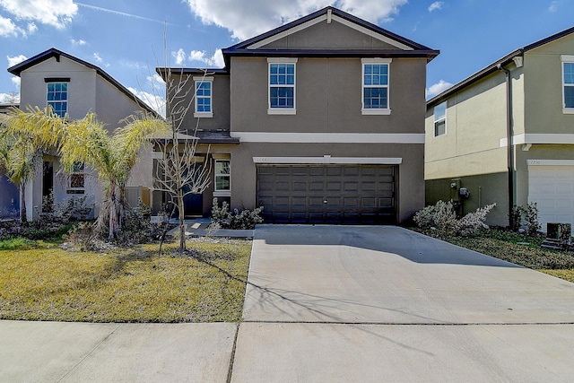 traditional-style house with driveway, an attached garage, and stucco siding