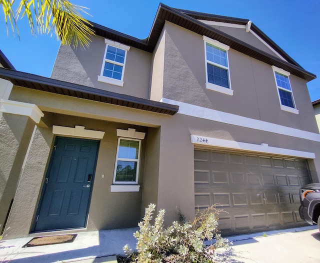 view of front of house with an attached garage and stucco siding