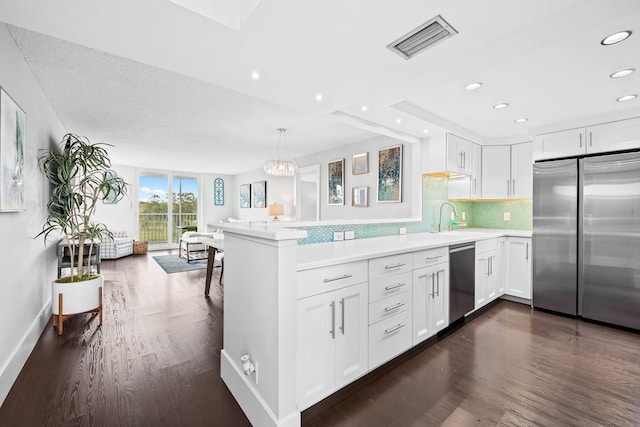 kitchen with stainless steel appliances, visible vents, backsplash, open floor plan, and a peninsula