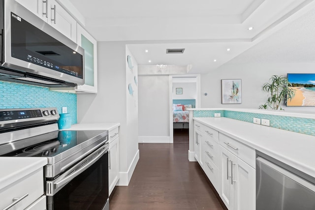 kitchen with appliances with stainless steel finishes, light countertops, and visible vents