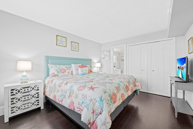 bedroom with connected bathroom, a closet, and wood finished floors