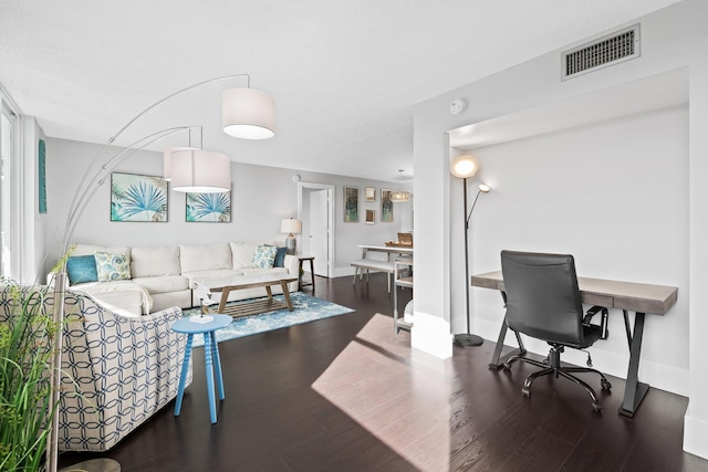 office with baseboards, visible vents, and wood finished floors