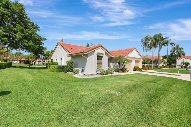 view of front facade featuring a front yard, a tile roof, and stucco siding