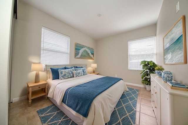 bedroom featuring light tile patterned floors and baseboards