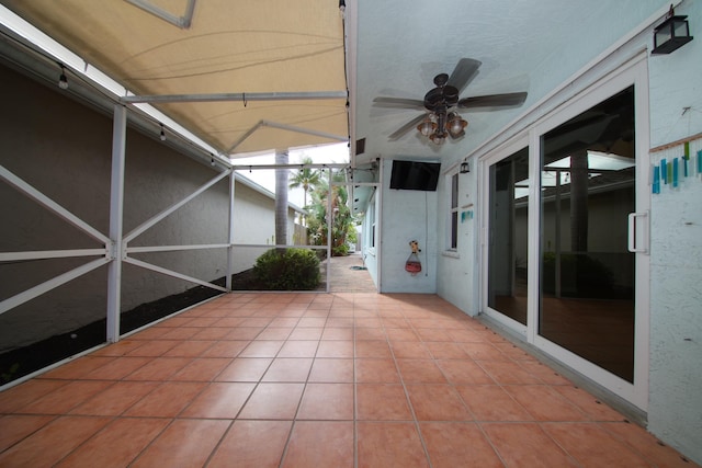 unfurnished sunroom featuring ceiling fan