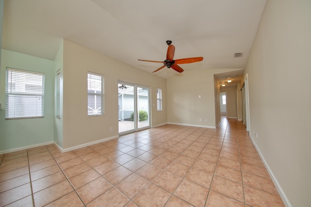 spare room featuring light tile patterned flooring, visible vents, baseboards, and ceiling fan