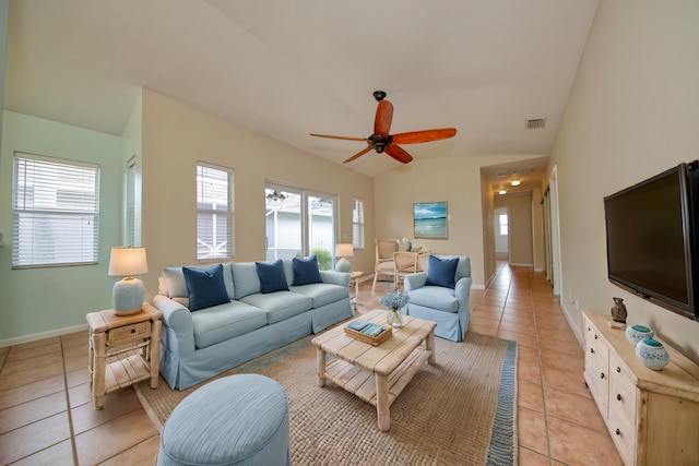 living room featuring light tile patterned floors, visible vents, baseboards, ceiling fan, and vaulted ceiling