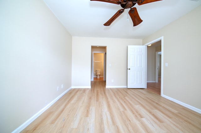 unfurnished bedroom with ensuite bath, baseboards, light wood-type flooring, and ceiling fan