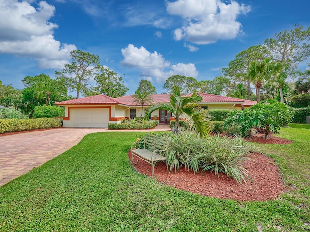 view of front of home with a garage, a front yard, decorative driveway, and a tile roof