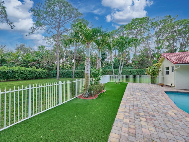 view of yard featuring a patio area, a fenced backyard, and a fenced in pool