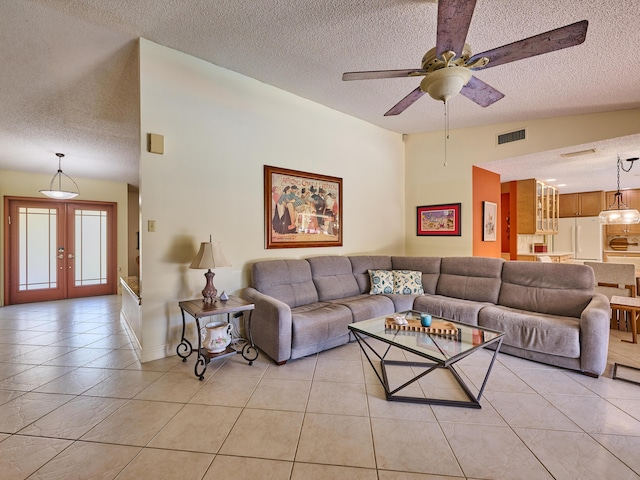 living room with visible vents, lofted ceiling, a textured ceiling, french doors, and light tile patterned flooring