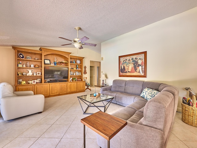 living room with a ceiling fan, light tile patterned flooring, vaulted ceiling, and a textured ceiling