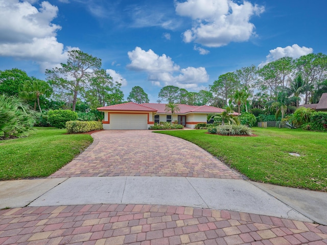 view of front of home with an attached garage, a tile roof, decorative driveway, stucco siding, and a front yard