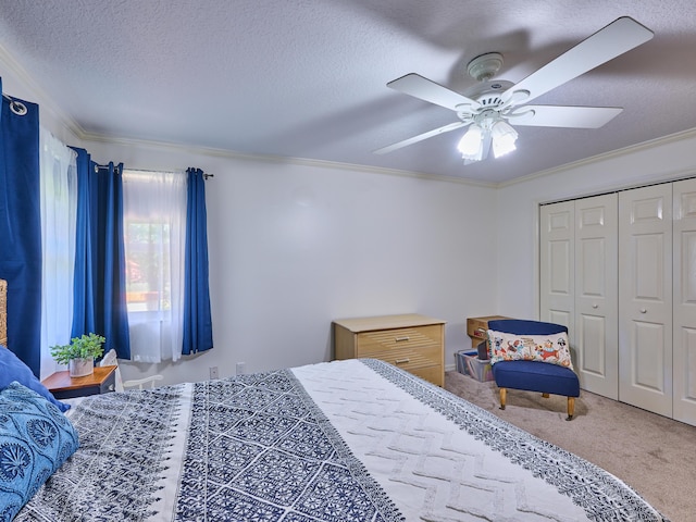 carpeted bedroom featuring ornamental molding, a closet, ceiling fan, and a textured ceiling