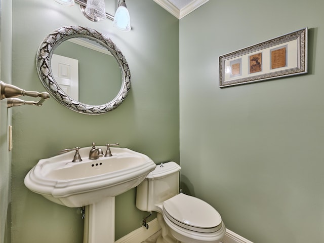 half bathroom with toilet, baseboards, and ornamental molding