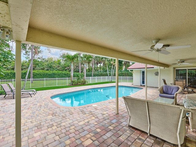 view of swimming pool featuring a patio area, ceiling fan, and a fenced backyard