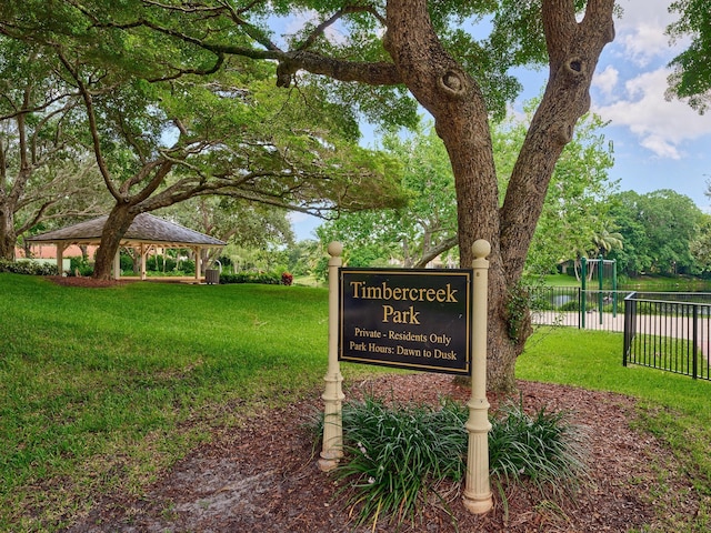 view of property's community featuring fence, a gazebo, and a lawn