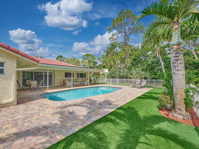 view of pool featuring a lawn, fence, a fenced in pool, and a patio