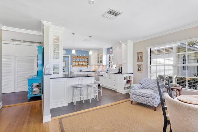 interior space featuring visible vents, white cabinets, open shelves, dark countertops, and glass insert cabinets