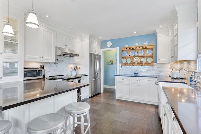 kitchen featuring stainless steel appliances, dark countertops, white cabinets, and under cabinet range hood