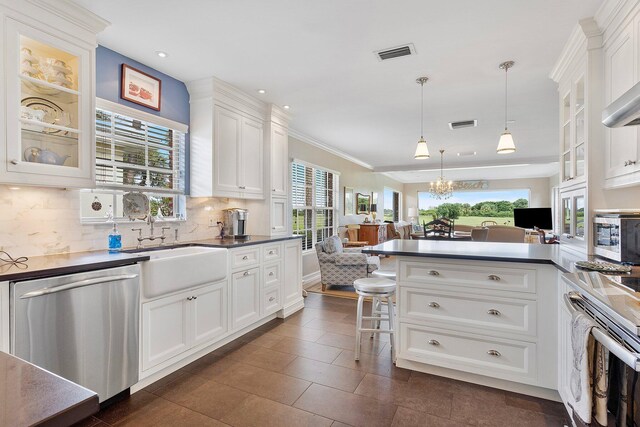 kitchen with tasteful backsplash, visible vents, appliances with stainless steel finishes, open floor plan, and a sink