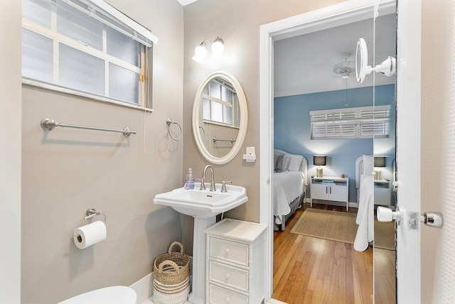 ensuite bathroom with toilet, wood finished floors, and ensuite bathroom