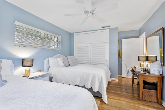 bedroom with a ceiling fan, a closet, visible vents, and light wood finished floors