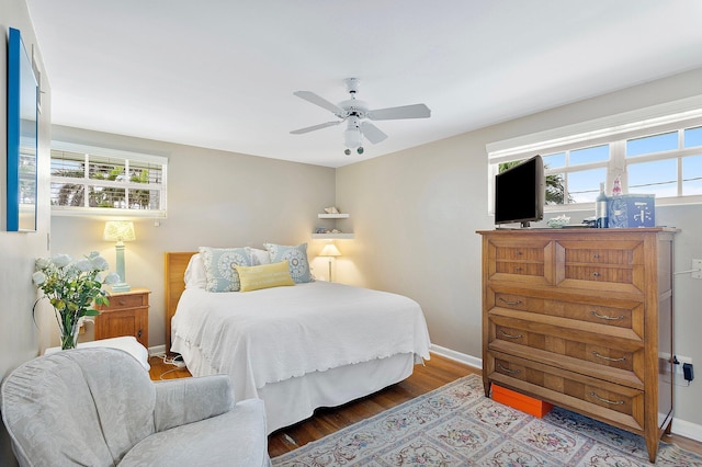 bedroom with wood finished floors, a ceiling fan, and baseboards