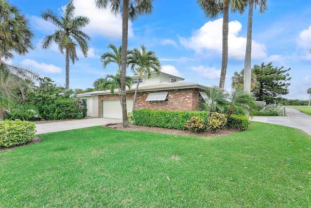 view of front of home featuring an attached garage, a front lawn, concrete driveway, and brick siding