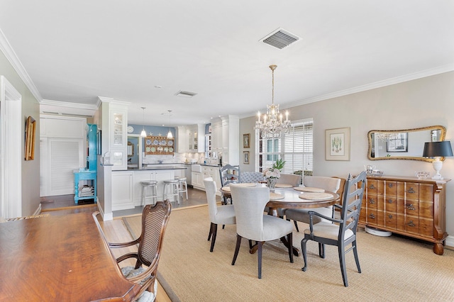 dining area featuring an inviting chandelier, visible vents, and crown molding