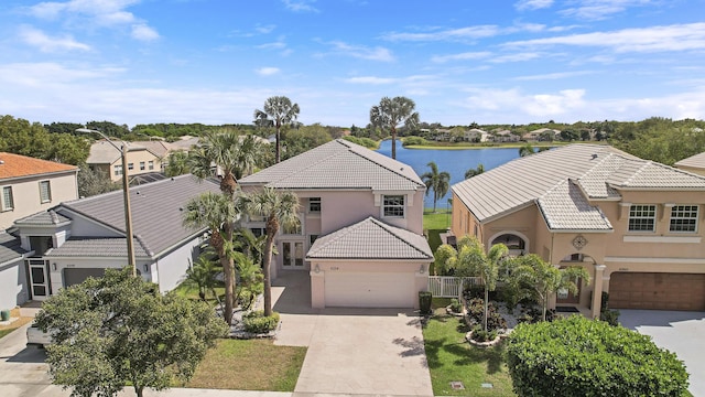 view of front of house featuring a garage, concrete driveway, a tile roof, and stucco siding