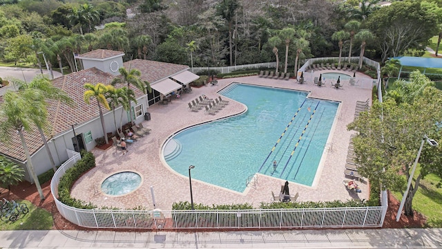 pool featuring a patio, a community hot tub, and fence