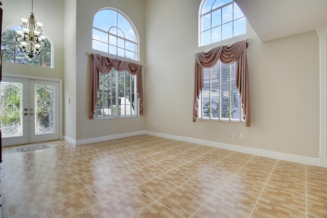 foyer with tile patterned flooring, french doors, plenty of natural light, and baseboards