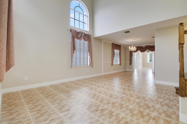 interior space featuring baseboards, visible vents, a towering ceiling, an inviting chandelier, and light tile patterned flooring